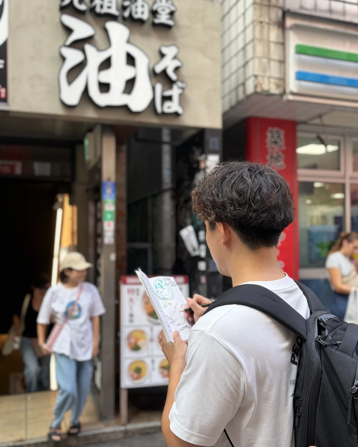 Writing down a kanji spotted on a shop sign in Tokyo