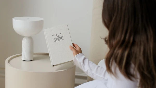 Picking up the journal from a side table